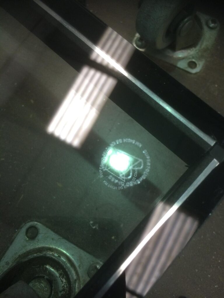 closeup of a British kite mark, etched, on to glass 