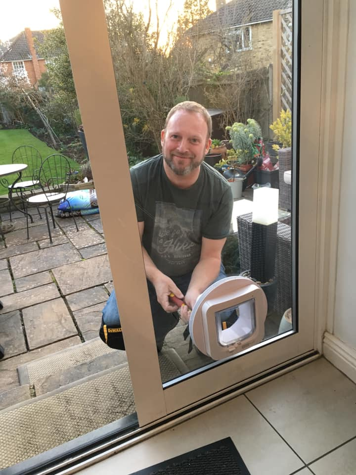 Peter fitting cat flap in an DGU fitted in an Aluminium wraparound door