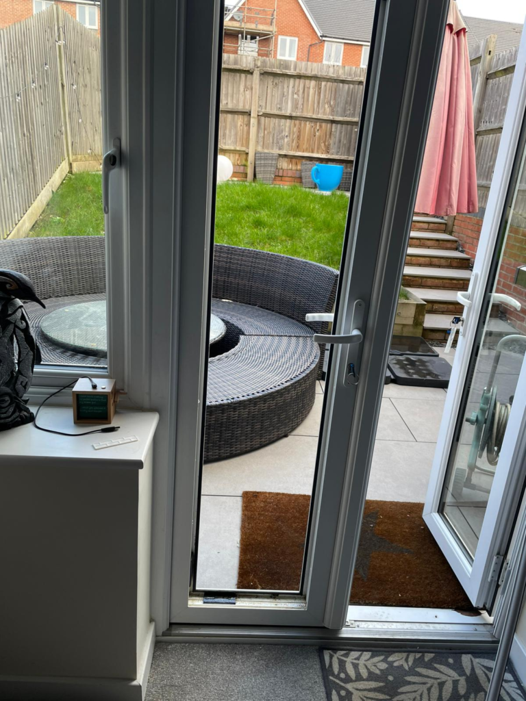 French doors with DGU removed from one of the doors, showing view of garden